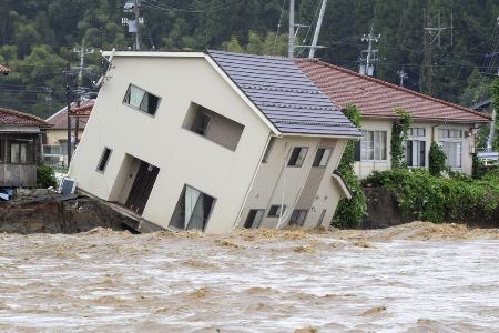 　２０２４年９月の能登半島での豪雨で、増水した若山川に地面をえぐられ傾いた住宅＝石川県珠洲市