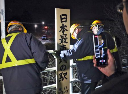 　ＪＲ東根室駅ホーム上の「日本最東端の駅」と記された表示を取り外す作業員＝１４日夜、北海道根室市