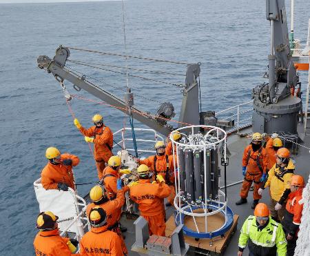 　南極観測船「しらせ」で採水装置の投入準備をする観測隊や海上自衛隊の隊員たち＝６日、南大洋（南極観測隊同行記者撮影）