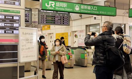 　東北新幹線の運行状況を伝える掲示の前で立ち止まる人＝７日午前、ＪＲ盛岡駅