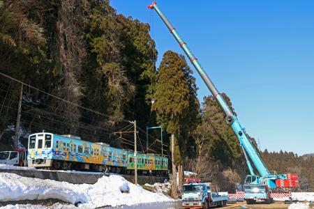 　クレーン車でつり上げられるえちぜん鉄道の列車＝１０日午前９時５分、福井県勝山市