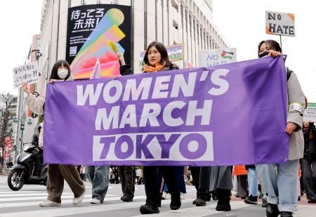 　国際女性デーに合わせて行われた「ウィメンズマーチ東京」で、横断幕を広げて行進する人たち＝８日午後、東京・渋谷