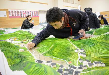 　石川県能登町小木地区の被災前を再現する模型を製作する神戸大大学院の中岡和貴さん