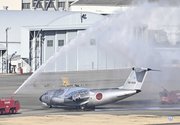 退最終とみられる飛行を終えて放水のアーチで出迎えられるＣ１初号機＝１４日午後４時、各務原市内