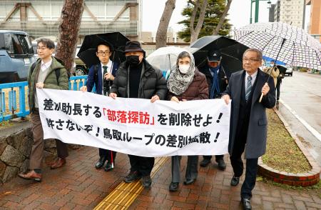 　横断幕を手に新潟地裁に向かう原告や支援者ら＝５日午後