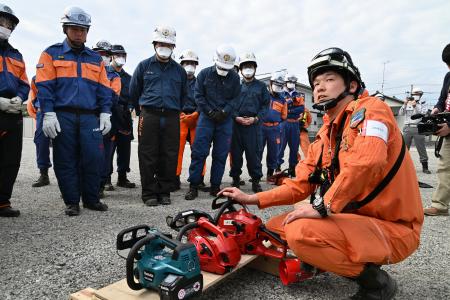 　警察や消防の合同地震対応訓練に講師として参加し、チェーンソーの使い方を教える消防士の新妻拓弥さん＝２日、福島県いわき市